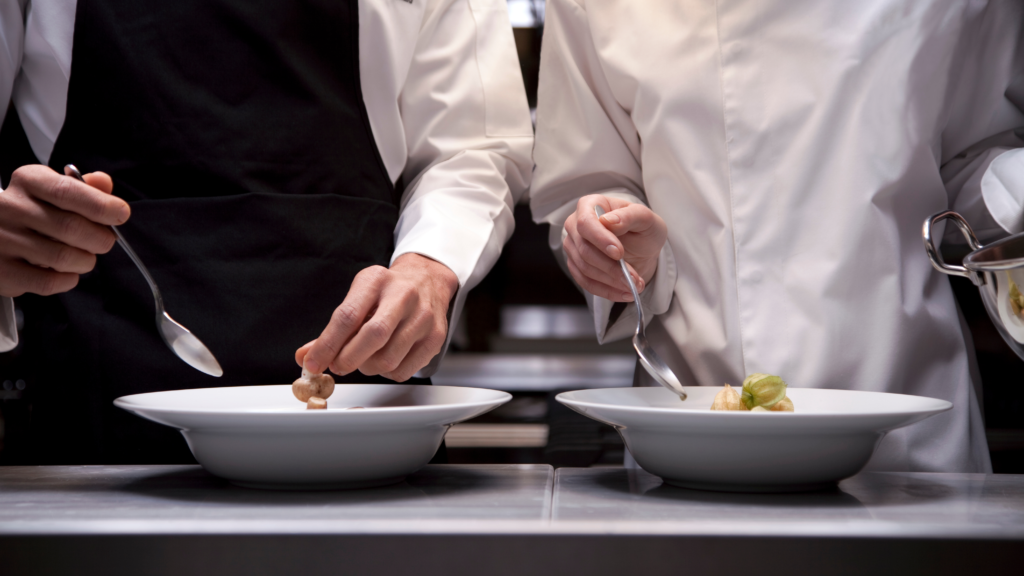 Dois cozinheiros fazendo pratos gourmet.